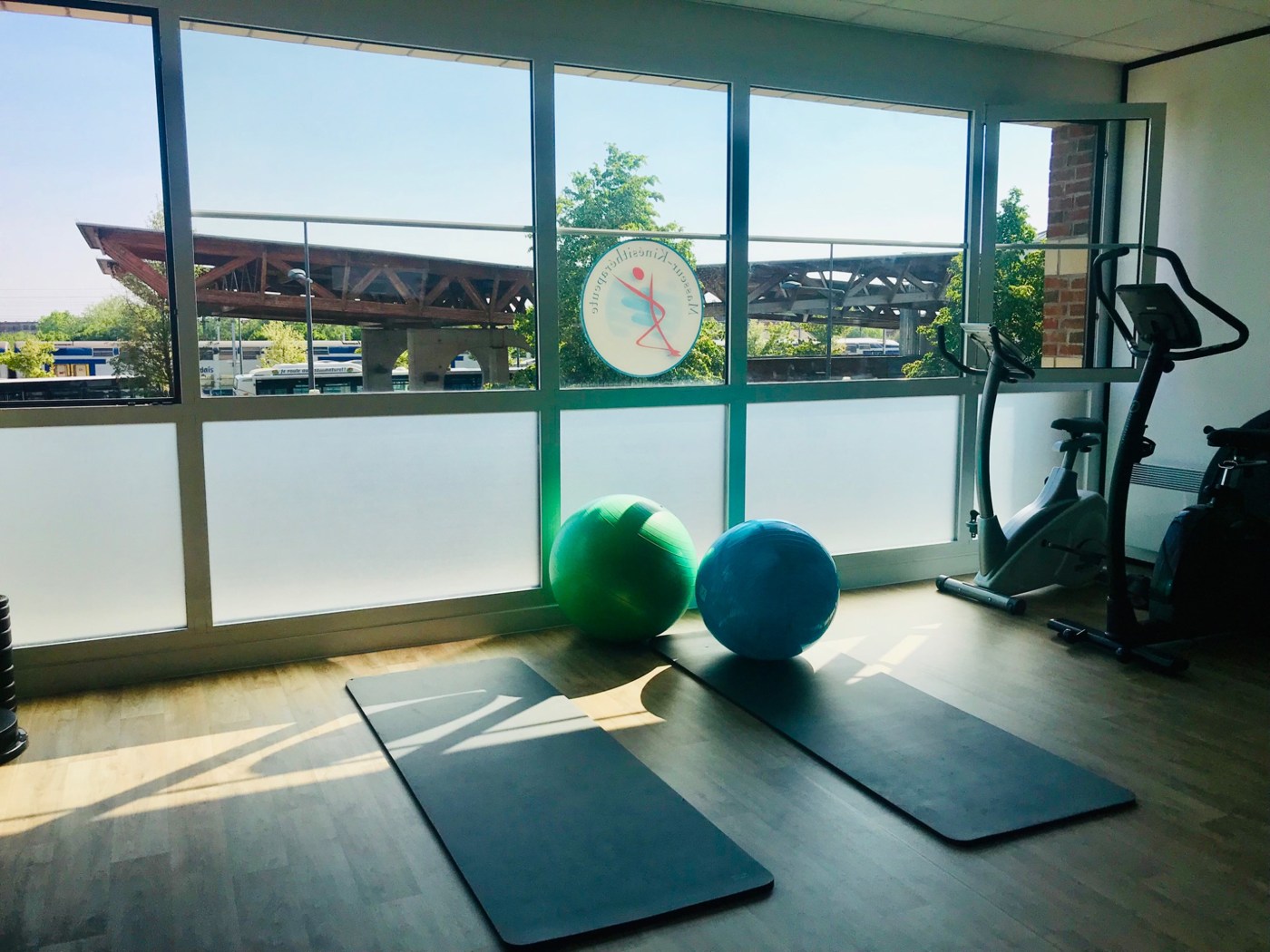 Espace de rééducation lumineux du cabinet, avec tapis, ballons et vélos